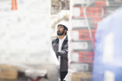 Young man wearing hard hat working in a warehouse