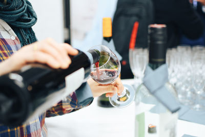 Midsection of woman holding wine glass