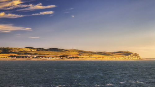 Scenic view of sea by buildings against sky