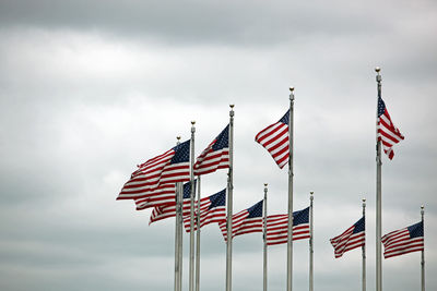 Low angle view of flag flags against sky