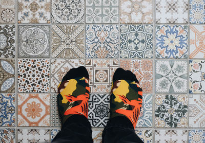 Low section of man standing on tiled floor