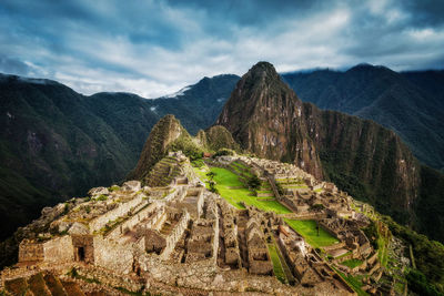 Scenic view of mountain range against cloudy sky