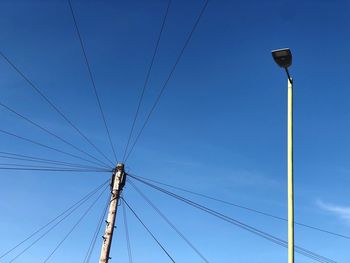 Low angle view of electricity pylon against clear sky