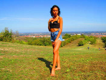 Full length portrait of young woman standing on land