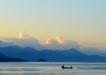 Silhouette boat in sea against sky during sunset