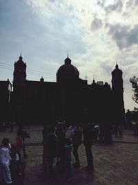 Tourists in front of building against clear sky