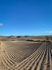 Scenic view of desert against clear blue sky