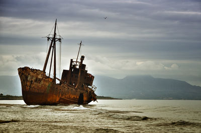 Sailboat on sea shore against sky