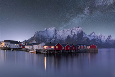 Spectacular scenery of glowing stars of milky way in night sky over over residential houses located in highlands near lake in norway at night