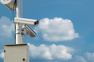 Cctv security camera isolated on blue sky background.