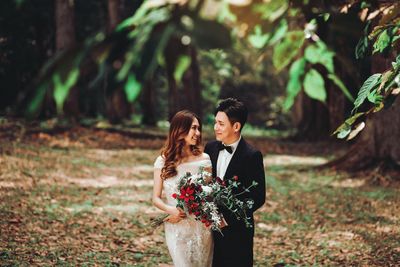 Young couple standing against plants