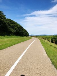 Empty road by landscape against sky