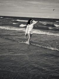Woman standing on beach against sea