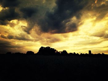 Silhouette of landscape against cloudy sky