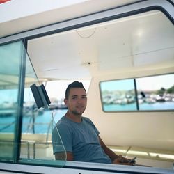 Portrait of young man sitting in window