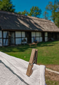 Wooden post by house on field against trees