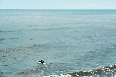 Man surfing in sea against sky