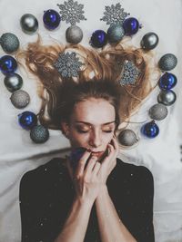 High angle view of beautiful woman lying on bed with christmas ornaments