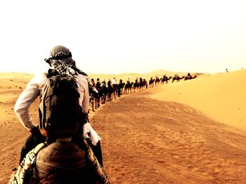 Rear view of people in sand