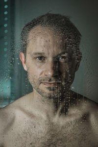 Portrait of young man standing against wall