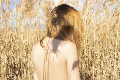 Rear view of woman standing at farm