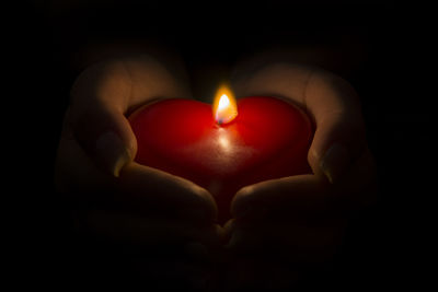 Close-up of human hand holding candle