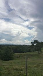 Scenic view of grassy field against cloudy sky