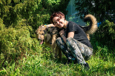 Young woman with dog on grassy field