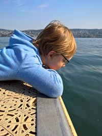 Boy in sea against sky