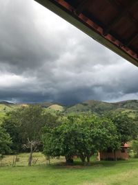 Scenic view of green landscape against cloudy sky