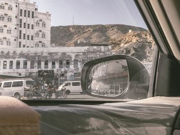 Reflection of man on side-view mirror