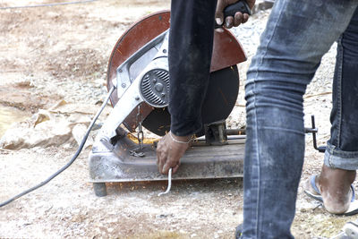 Low section of man working on motorcycle