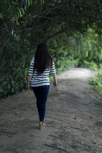 Rear view of woman walking on footpath