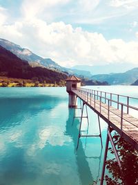 Swimming pool by lake against sky