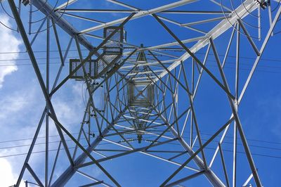 Low angle view of electricity pylon against clear blue sky