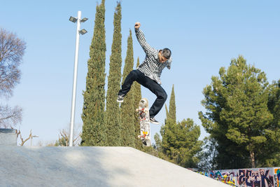 Man skateboarding on ramp in park