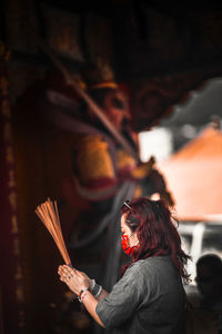 Portrait of woman with arms raised standing at night