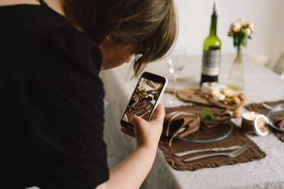 Video blog. a young woman is filming kitchen goods for her online store on her phone camera.