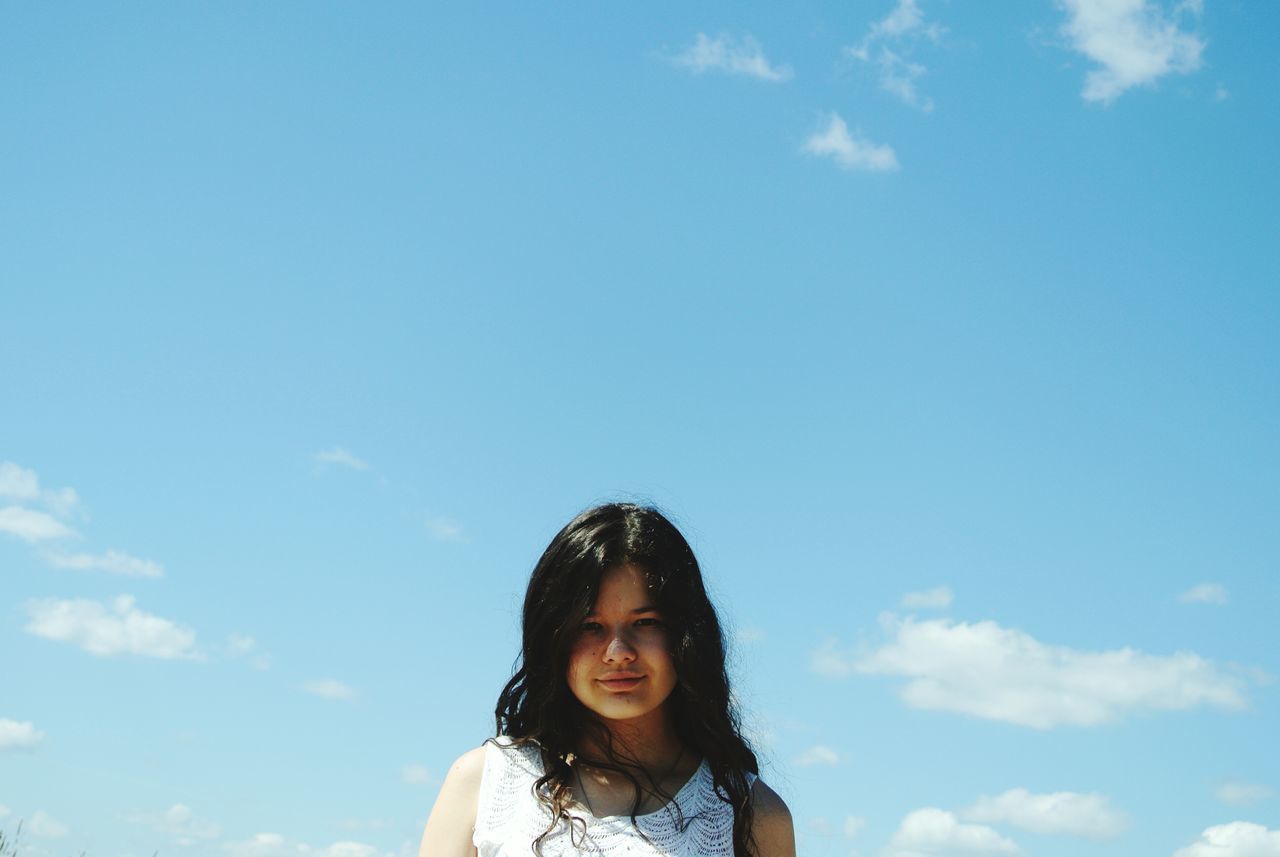 person, looking at camera, portrait, young adult, lifestyles, smiling, leisure activity, front view, headshot, sky, happiness, young women, casual clothing, waist up, blue, head and shoulders, sunglasses