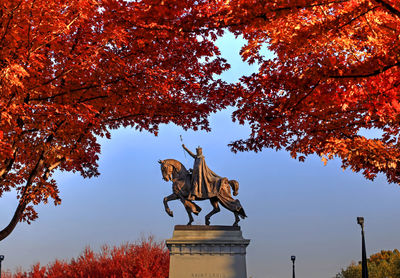 Low angle view of statue against sky during autumn