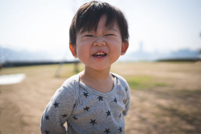 Portrait of smiling baby boy making face while standing on land