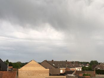 Houses against cloudy sky