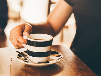 Midsection of coffee cup on table