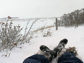 Low section of person on snow covered field