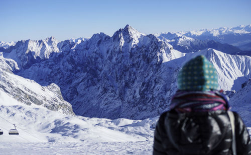 Rear view of a person on snow covered landscape