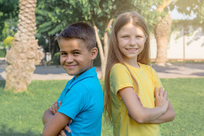 Portraits of a cheerful boy and girl on the background of the park.