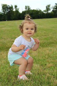 Portrait of cute baby girl on field
