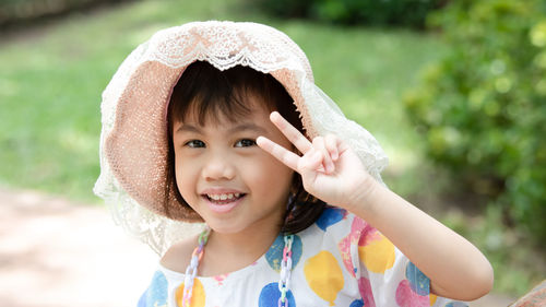 Portrait of happy charming 4 years old cute baby asian girl, little child smiling showing 2 fingers.