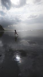 Man on beach against sky