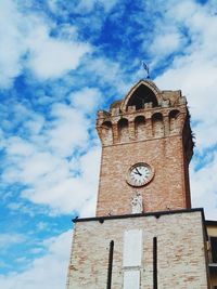 Low angle view of clock tower against cloudy sky